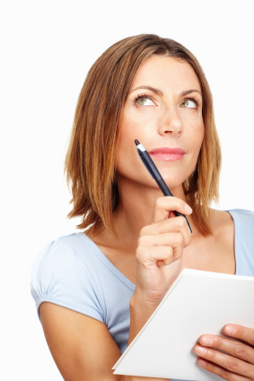 Beautiful business woman thinking while writing on notepad
